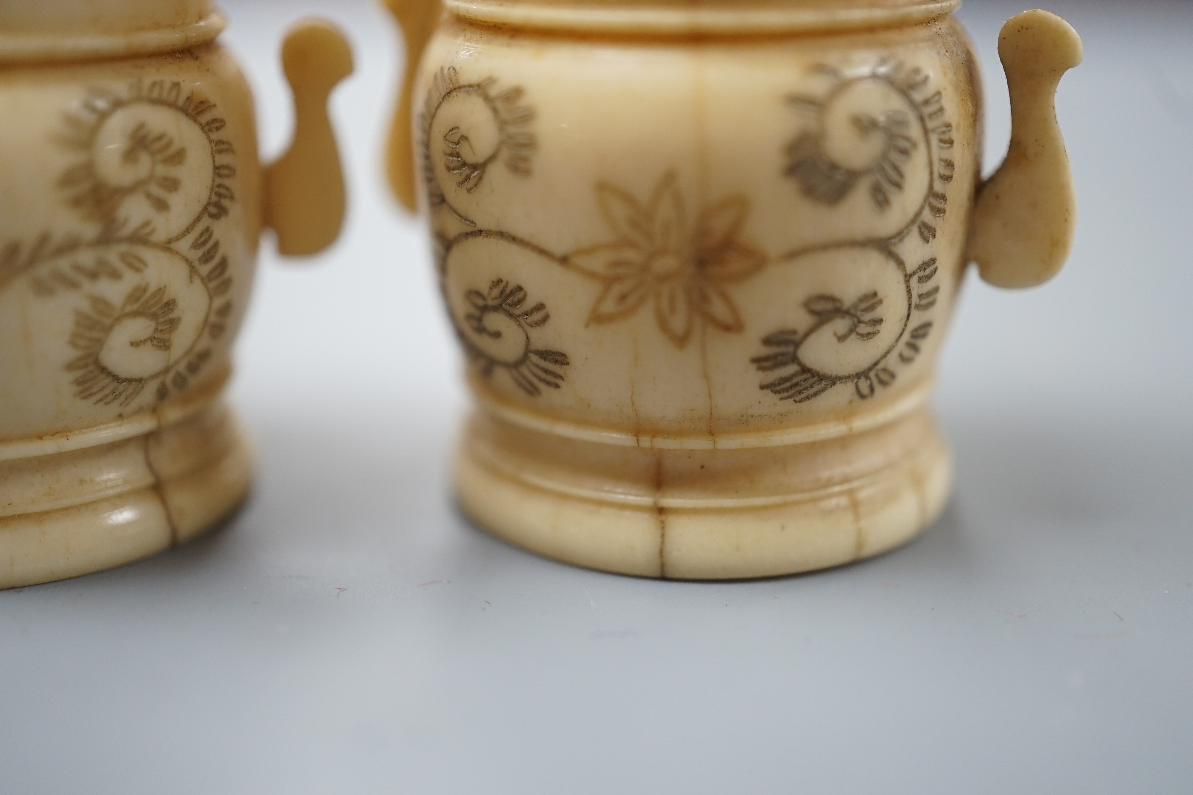 A pair of early 20th century Japanese miniature ivory vases, 5.3 cm, engraved with a lady and a wood netsuke in the form of a monkey holding a bamboo shoot (3)
